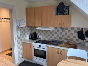 a small kitchen with a stove and a sink at Chez Carine in Schiltigheim