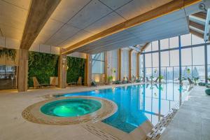 a large swimming pool in a building with a large window at Zlatibor Adoro Titova Vila in Zlatibor
