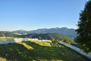 une colline avec une clôture et des montagnes en arrière-plan dans l'établissement Utopia Mountain resort Bjelasnica, à Bjelašnica