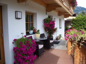 a patio with flowers and a table and chairs at Haus Emberger in Gerlos