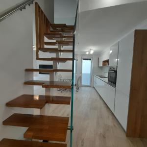 uma casa moderna com escadas de madeira numa cozinha em Villa Maboka em Zadar