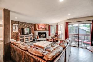a living room with a leather couch and a table at Cimarron Bear Condo: Fantastic Location, Sleeps 8 in Breckenridge