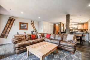 a living room with a leather couch and a table at Cimarron Bear Condo: Fantastic Location, Sleeps 8 in Breckenridge