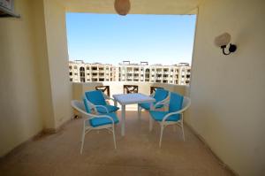 a balcony with a table and chairs and a window at ALFRDOUS LUXURY VACATION HOME NORTH COAST in Sīdī ‘Abd ar Raḩmān