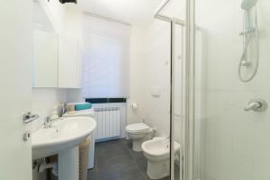 a white bathroom with a sink and a toilet at Un Angolo di Relax in Tavernola Bergamasca +50 photos