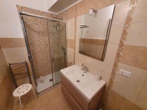 uma casa de banho com um lavatório, um chuveiro e um espelho. em Casa La Ferula apt2 vicino al mare e Taormina con balcone em SantʼAlessio Siculo
