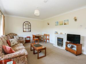 a living room with a couch and a television and a table at Newby in Gayton