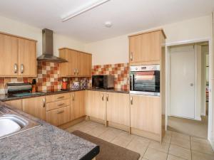 a kitchen with wooden cabinets and a sink at Newby in Gayton