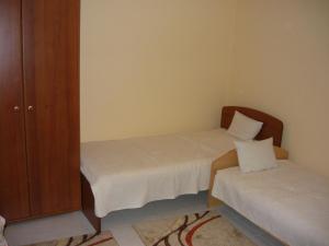 エゲルにあるGalagonyás apartmanの小さなベッドルーム(ベッド2台、キャビネット付)