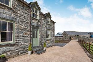 Casa de piedra con puerta verde y entrada en Waedog Bach en Llanfor