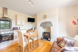 a kitchen and living room with a table and a stove at Waedog Bach in Llanfor