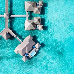 une vue aérienne sur un bateau dans l'eau dans l'établissement The St Regis Bora Bora Resort, à Bora Bora