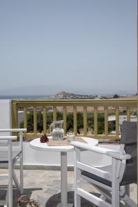 einen Tisch und Stühle auf einem Balkon mit Meerblick in der Unterkunft Vavoulas Village in Mikri Vigla