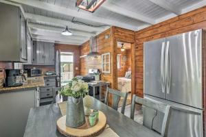 a kitchen with a stainless steel refrigerator and a table at Cozy Shaver Lake Cabin Less Than 1 Mi to Shaver Lake! in Shaver Lake