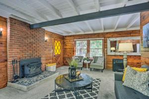 a living room with a fireplace and a brick wall at Cozy Shaver Lake Cabin Less Than 1 Mi to Shaver Lake! in Shaver Lake