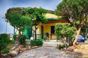 a yellow house with trees in front of it at Aegean Bliss Residences - Karfas in Karfas