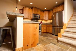 eine Küche mit Holzschränken und einem Edelstahlkühlschrank in der Unterkunft Black Bear 59 in Durango Mountain Resort