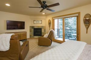 Schlafzimmer mit einem Bett, einem TV und einem Kamin in der Unterkunft Black Bear 59 in Durango Mountain Resort