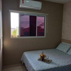 a bedroom with a bed and a window with a toy on it at Residencial Flats Botanicus 1 in Olímpia