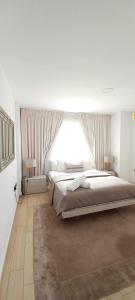 ein Schlafzimmer mit einem großen Bett und einem großen Fenster in der Unterkunft 5-Star Luxury Suite, Labone in Accra
