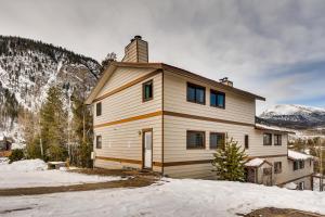 Una casa en la nieve con montañas al fondo en 216 Pitkin St Unit6, en Frisco