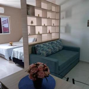 a living room with a couch and a bed at Residencial Flats Botanicus 1 in Olímpia