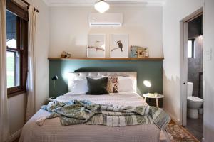a bedroom with a bed with a green headboard at Cabrito in Daylesford