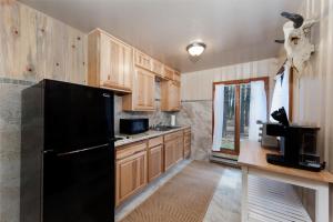 Una cocina con gabinetes de madera y un refrigerador negro. en 151 CR 200 1 Bedroom Cabin, en Durango