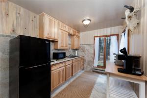 a kitchen with wooden cabinets and a black refrigerator at 151 CR 200 1 Bedroom Cabin in Durango