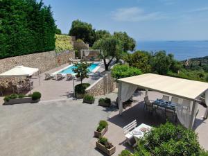 una vista su un patio con piscina e su una grande tenda bianca. di Athiri House Villa Corfu a Spartýlas