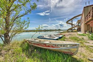a boat sitting on the side of a body of water at Lakefront Country Home with Waterslide and Trampoline! in Wheatland