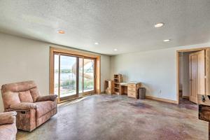 an empty living room with a couch and a chair at Lakefront Country Home with Waterslide and Trampoline! in Wheatland