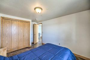 a bedroom with a blue bed and a wooden cabinet at Lakefront Country Home with Waterslide and Trampoline! in Wheatland