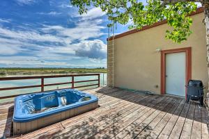 a hot tub sitting on a deck next to a building at Lakefront Country Home with Waterslide and Trampoline! in Wheatland
