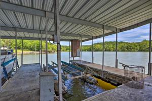 a dock with a boat in the water at Dragon Castle with Secret Passage, Dock, and Hot Tub in Camdenton