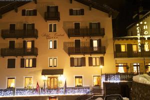 a large building with windows and balconies at night at Centrale in Courmayeur
