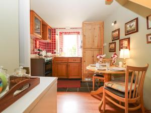 a kitchen with a wooden table and a kitchen with a sink at The Coach House in Duns