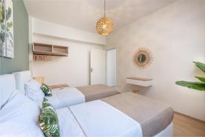two beds in a room with white walls at Villa VerdeBlu Rethymno Crete in Rethymno Town