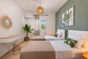 a bedroom with two beds and a potted plant at Villa VerdeBlu Rethymno Crete in Rethymno Town