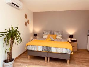 聖艾米隆的住宿－Maison De La Tour，一间卧室配有一张床和盆栽植物