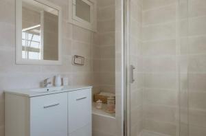 un bagno bianco con doccia e lavandino di Casa da Lota 1º, by Casas do Verão a Manta Rota Altre 33 foto