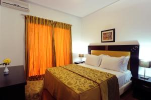 une chambre d'hôtel avec un lit et un rideau orange dans l'établissement Farah Inn Ifrane, à Ifrane
