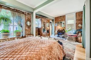 a bedroom with a large bed and a brick wall at 1374 S Pennsylvania St in Denver +21 photos