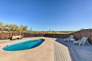 una piscina con 2 sillas y una valla de madera en Tucson Oasis La Casa de las Palmas with Pool!, en Tucson