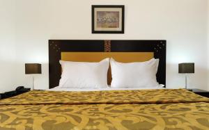 a bedroom with a large bed with two lamps at Farah Inn Ifrane in Ifrane