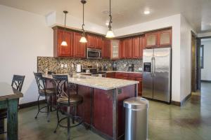 a kitchen with wooden cabinets and a island with bar stools at La Dolce Vita Villas 10 in Moab