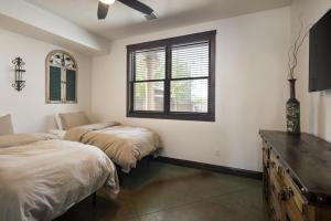 1 dormitorio con 2 camas y ventana en La Dolce Vita Villas 10 en Moab
