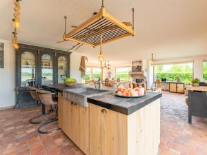 a kitchen with a large island with a bowl of fruit on it at Villa Noortem in Maldegem