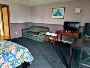 ハンプトンにあるRegal Inn Hampton Beachのベッド、椅子、デスクが備わる客室です。