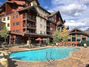 a hotel with a swimming pool in front of a building at Peregrine Point 205 in Durango Mountain Resort